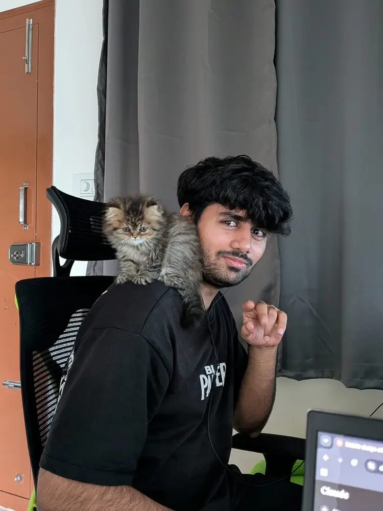 Coco sitting on Anshu's shoulder while he works at a desk
