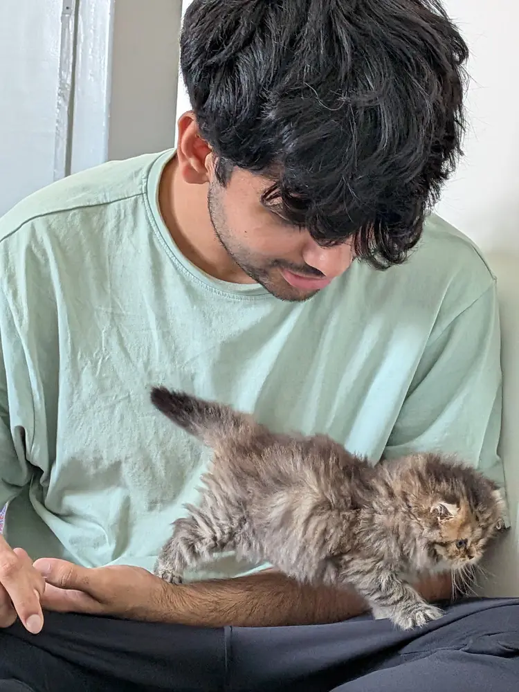 Anshu holding Coco on the day she arrived, looking down at her